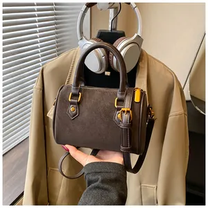 Detailansicht einer braunen Vintage-Boston-Handtasche mit goldener Hardware.