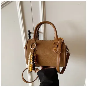 Detailansicht der braunen Vintage-Boston-Handtasche aus Leder mit Holzperlen-Anhänger