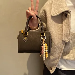 Vintage Boston-Handtasche für Damen mit dekorativem, buntem Perlen-Quasten-Anhänger.