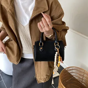 Klassische schwarze Boston-Handtasche für Damen mit einem schicken Perlenanhänger
