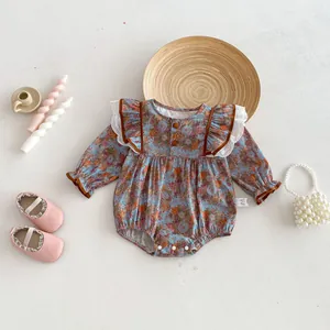 Close-up of baby girl floral long sleeve romper with cute ruffles and buttons detail.