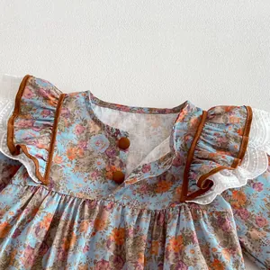 Baby girl floral long sleeve romper detail, cute ruffle shoulder and brown piping trim.