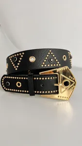 Closeup of punk style black leather belt featuring gold studs, rhinestones and metal buckle.