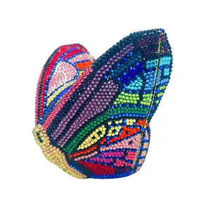Dettaglio macro della pochette da sera a forma di farfalla con strass colorati