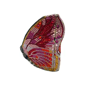 Dettaglio ravvicinato delle ali di farfalla in strass colorati su una borsa clutch di lusso.
