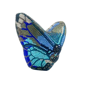 Dettaglio di una lussuosa borsa a pochette a farfalla con cristalli blu e argento.