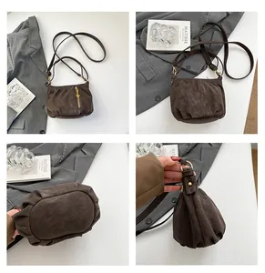 Detail view of brown ruched crossbody bag, showcasing texture and hardware details.