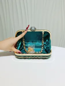Vista dettagliata di una borsa da sera aperta decorata con cristalli verde smeraldo.