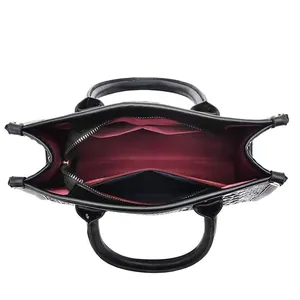 Draufsicht auf schwarze Kroko-Handtasche mit weinroten Innenfächern und Reißverschluss