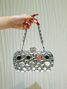 Primo piano della pochette da sera argento con diamanti in vetro e chiusura in cristallo.