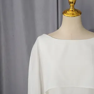 Detail van een elegante witte avondjurk met boothals en een stijlvol sjaalontwerp.