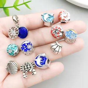 Collection of ocean-themed alloy charms with blue and red enamel details on palm