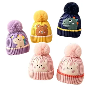 Assorted knitted baby beanies with cute animal embroidery and large fur pom poms.