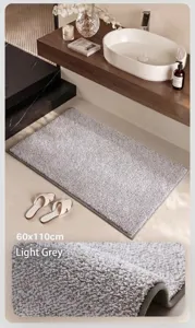 Close-up of thick plush light gray absorbent bath mat in a modern bathroom setting