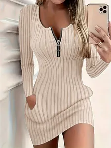Dettaglio dell'abito in maglia a coste beige con cerniera frontale e tasche.