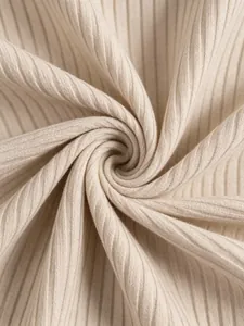 Dettaglio ravvicinato del tessuto a maglia a coste beige per eleganti abiti invernali