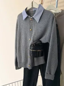 Vista dettagliata del cardigan grigio con colletto a righe e bottoni dorati