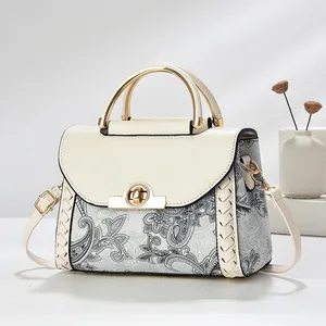 Elegant luxury women's handbag featuring vintage paisley print and gold metallic handle