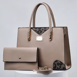Detailed shot of a stylish beige handbag and matching wallet set on a display stand