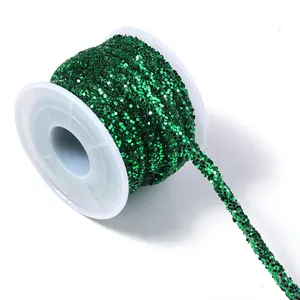 Close up detail of dark green sequin braided rope trim on white plastic spool craft supply