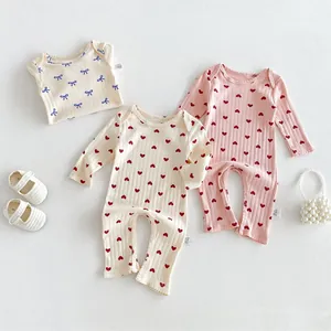 Infant cotton ribbed romper set with cute heart and bow prints, soft baby clothes detail view.
