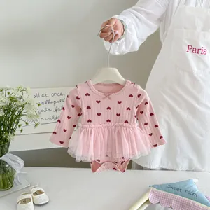 Roze baby meisjes shirtjurk met lange mouwen, hartjesprint en fijne tule zoom.