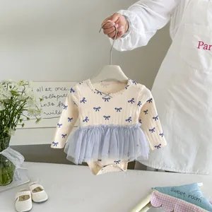 Gedetailleerd overzicht van schattige babyromper met lange mouwen,strikjes en tule rok.