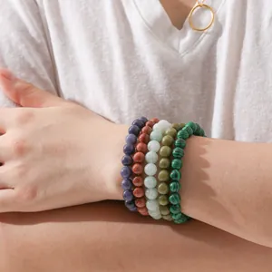 Detailed view of colorful natural stone beaded bracelets stacked gracefully on the wrist.
