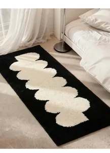 Black and white wavy bedside rug detail, soft fluffy floor mat for bedroom decor.