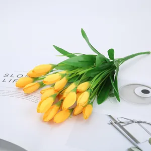Artificial yellow tulip flower bouquet detail, realistic fake floral decor for home table.
