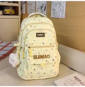 Dettagli dello zaino giallo con stampa a stelle, tasche frontali e grazioso ciondolo orsetto.