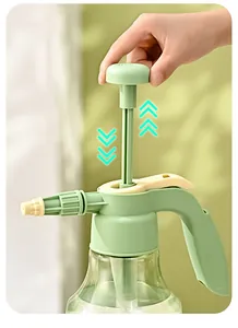 Gros plan d'une main appuyant sur la pompe d'un vaporisateur de jardin