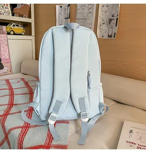 Light blue canvas backpack detail view, casual school bookbag with secure straps and zip.