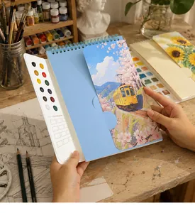Close-up of portable watercolor book with built-in 12-color palette and mixing area.