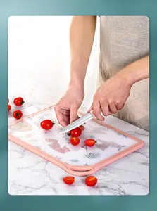 Close-up view of slicing small tomatoes on a pink cartoon animal pattern cutting board
