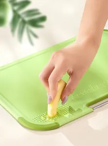 Detail of green baby food cutting board with built-in ginger and garlic grater