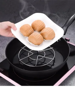 Functional stainless steel steaming rack shown inside a black pan with fresh buns