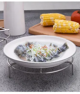 Detailed view of high-legged stainless steel steaming rack holding a plate of steamed fish