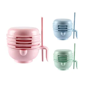 Multi-color manual baby food grinder set including bowl and pestle for fruit puree.