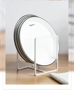 Scolapiatti bianco in stile giapponese con quattro piatti in ceramica su tavolo in legno