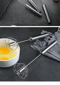 Close-up detail of two semi-automatic stainless steel egg whisks on a kitchen counter