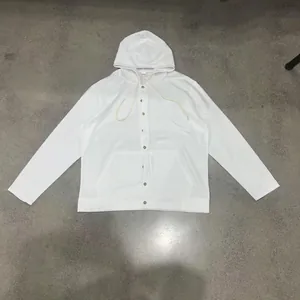 Flat lay view of a white hooded long-sleeve cotton linen shirt with brown buttons.