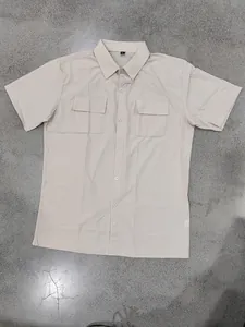 Flat lay detail of a beige men's quick-dry tactical shirt with double chest pockets.