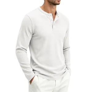 Detail of white waffle knit Henley shirt with button neckline and ribbed texture.