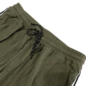 Detailed close-up view of olive green corduroy sweatpants with drawstring waist