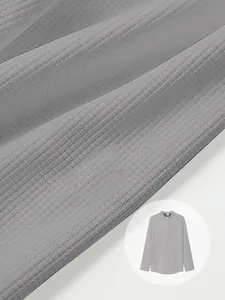 Close-up of gray waffle knit fabric texture on men's long sleeve henley polo shirt.
