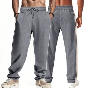 Detailed view of grey striped corduroy joggers with side stripes and drawstring waist