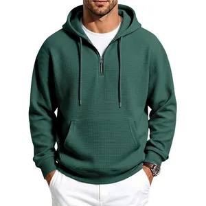 Detail view of men's dark green waffle knit hoodie with half-zip and kangaroo pocket.
