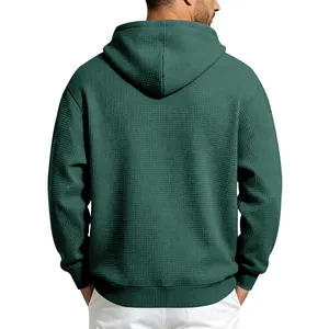 Back view of a men's dark green waffle knit hoodie with a casual loose fit.