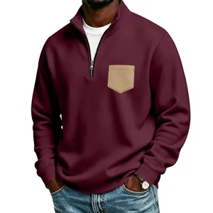 Detail of men's burgundy half-zip sweatshirt with khaki pocket and stand collar.